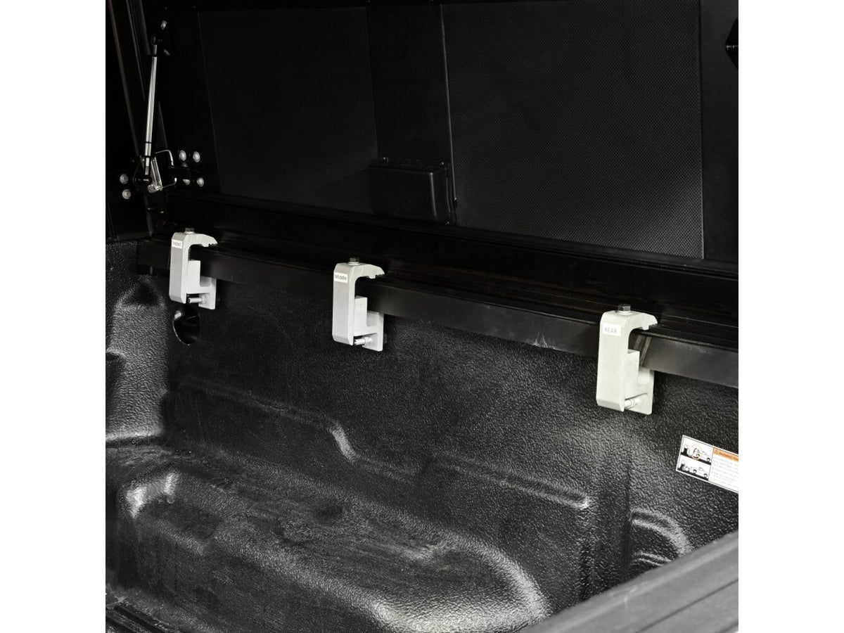 Trunk of a vehicle with cargo hooks and a toolbox.